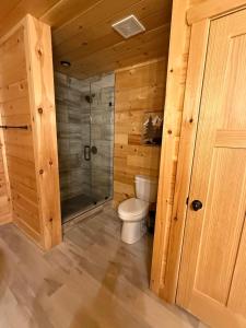 Un baño de madera con inodoro y ducha. en Savannah Smiles, en Williamsburg 16 fotos más