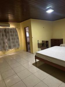 ein Schlafzimmer mit einem Bett und einem Tisch und einem Fenster in der Unterkunft Casa fazenda Paracuru in Paracuru