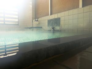 a swimming pool with a person in the water at Lodge Yukiyama in Nozawa Onsen