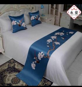 a bed with a blue blanket with flowers on it at Trinity S t a y in Benoni +16 photos