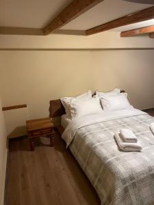 Un dormitorio con una cama con sábanas blancas y una mesa. en Capris Rustic Ηouse with Mountain View, en Archaia Feneos