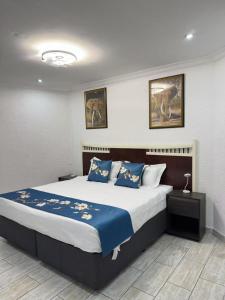 a bedroom with a large bed with blue sheets at Trinity S t a y in Benoni