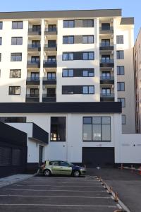 Un coche aparcado en un estacionamiento frente a un edificio. en Il sogno apartman, en Vranješ