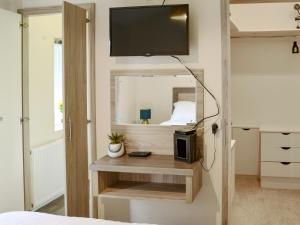 Un dormitorio con una cama y un televisor en una pared. en Ocean Glade - Uk32963, en Corton 9 fotos más