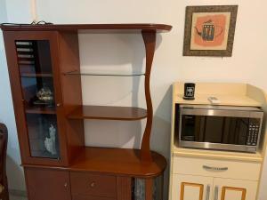 un meuble en bois avec un micro-ondes à côté d'un comptoir dans l'établissement Fully furnished apartment Samborondón Guayaquil, à SamborondÃ³n