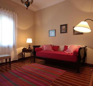 a living room with a red couch and a window at Solar De La Plaza in Salta