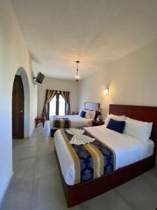 Un dormitorio con dos camas y un televisor. en Hotel Boutique Don Faustino, en Bernal