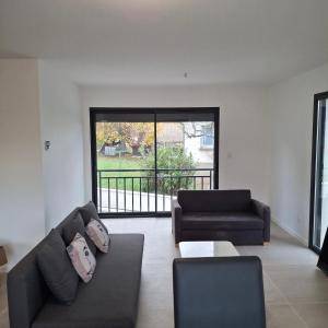 ein Wohnzimmer mit zwei Sofas und einem großen Fenster in der Unterkunft Villa de la trêve in Malleval