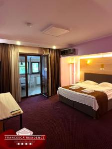 Una habitación de hotel con una cama grande y un balcón. en Francesca Residence, en Bucarest