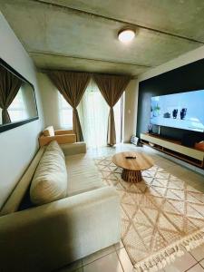 a living room with a couch and a table at Felinga Guest House in Centurion