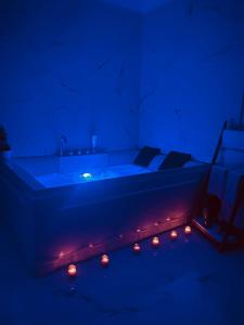 a dark room with a tub with candles in it at Nuvola Luxury suite in Turin +14 photos