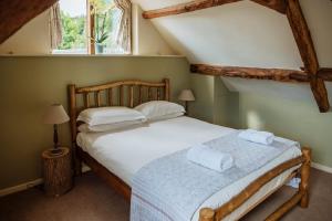 une chambre avec un lit avec deux serviettes dessus dans l'établissement Hogchester Cottage, à Bridport