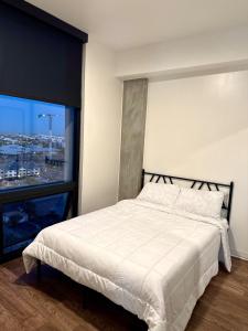 a bedroom with a white bed and a large window at 2bd 2bth Highrise in the heart of Roosevelt District! in Phoenix