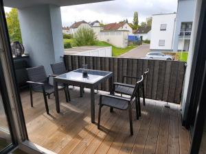 a patio with a table and chairs on a deck at Annas Ferienwohnung in Wallerfangen +12 photos