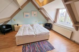 ドンブルグにあるHello Zeeland - Westweg 9Bのベッドルーム1室(ベッド1台、屋根裏部屋の椅子付)