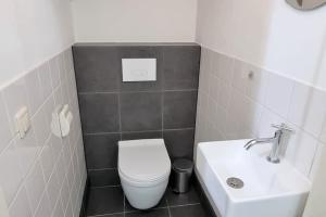 ドンブルグにあるHello Zeeland - Westweg 9Bの白いトイレと洗面台のあるバスルーム