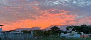 un coucher de soleil avec les montagnes en arrière-plan dans l'établissement Casa amigos Comala, à Comala
