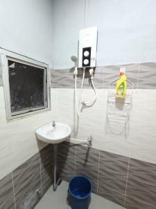 baño con lavabo y extintor de incendios en Hotel Bajet DNOOR Kota Bharu, en Kota Bharu