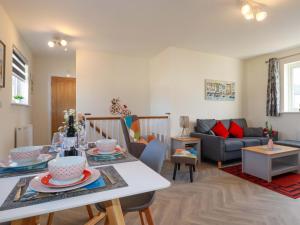 un soggiorno con un tavolo e un divano di Yonja Homes a St Austell