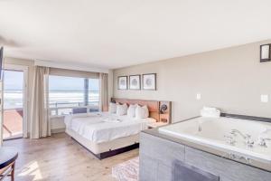 リンカーンシティにあるBeachfront Manor Hotelのベッドとバスタブ付きのホテルルームです。 +10枚の写真