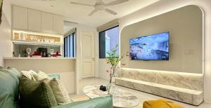 a living room with a couch and a tv on the wall at Jacuzzi with Starry Sky Bedroom-7pax in Malacca