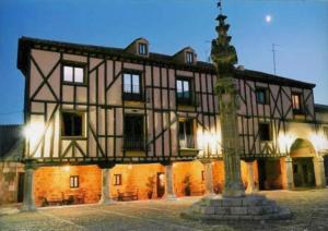 a large building with a clock in front of it at Posada Restaurante Ducal in Peñaranda de Duero
