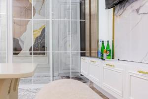 a bathroom with white cabinets and a glass shower at 7 Star Apartments in Tashkent +52 photos