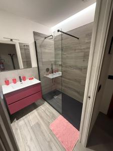 een badkamer met een roze wastafel en een douche bij Il Paese delle Vacanze by Elisa in Omegna
