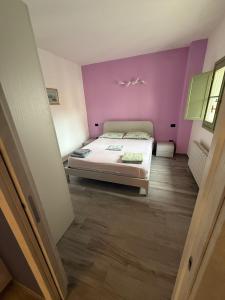 een slaapkamer met een bed en een paarse muur bij Il Paese delle Vacanze by Elisa in Omegna