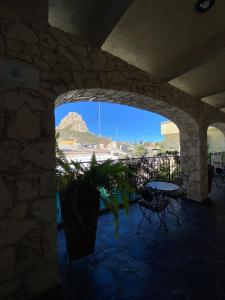 un arco con una mesa y sillas y una montaña en Hotel Boutique Don Faustino, en Bernal