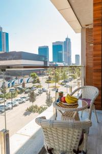 Una mesa y sillas en un balcón con vista a una ciudad. en 7 Star Apartments, en Tashkent