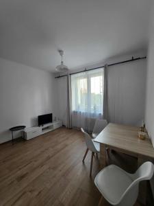 a living room with a table and chairs and a television at Kawalerka Krasińskiego in Kraśnik +4 photos