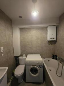 a bathroom with a toilet and a washing machine at Kawalerka Krasińskiego in Kraśnik