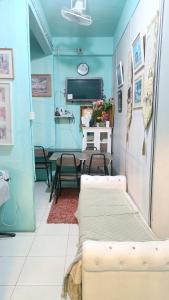 Habitación azul con mesa, sillas y sofá en Hotel Bajet DNOOR Kota Bharu, en Kota Bharu