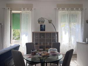 a dining room with a glass table and chairs at Alice's House in Civitavecchia