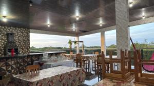 a restaurant with tables and chairs on a balcony at Hotel Caribe de Alter - Alter do Chão in Santarém