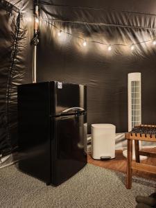 uma geladeira preta e uma mesa em uma tenda em 山林間 - 露營 旅居 Camping & BNB in forests 需先匯款完成預訂 em Taian