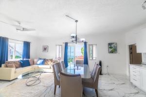 a living room with a table and a couch at Hibiscus Charm in Red Hills