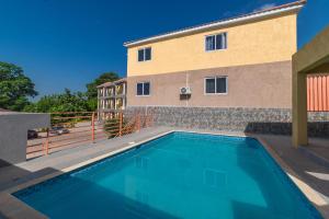 a swimming pool in front of a building at Hibiscus Charm in Red Hills