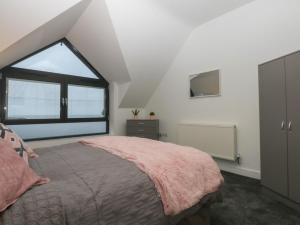 a bedroom with a bed and a large window at 2 Harbour Lights in Cemaes Bay