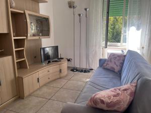 a living room with a blue couch and a tv at Alice's House in Civitavecchia