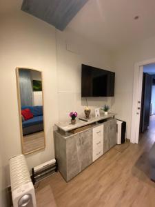 a living room with a television and a mirror at APARTAMENTOs URDAIBAI 2 in Bermeo
