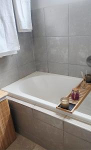 a bathroom with a bathtub with a tray on it at Felinga Guest House in Centurion