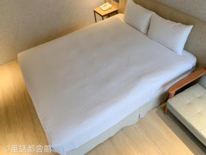 een groot bed in een kleine kamer met een tafel bij Fairy Tale City Motel in Hualien +66 foto's