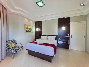 een slaapkamer met een groot bed en een stoel bij Luxury and Comfort, Jacuzzi, Spectacular Pool in Foz do Iguaçu +72 foto's