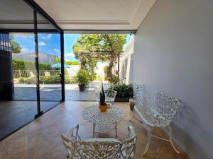 een patio met een tafel en stoelen bij Luxury and Comfort, Jacuzzi, Spectacular Pool in Foz do Iguaçu