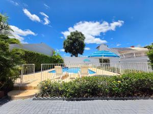 een zwembad met stoelen en parasols op een patio bij Luxury and Comfort, Jacuzzi, Spectacular Pool in Foz do Iguaçu