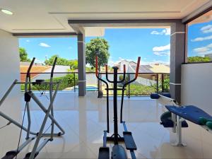 een kamer met een fitnessruimte en uitzicht op een zwembad bij Luxury and Comfort, Jacuzzi, Spectacular Pool in Foz do Iguaçu
