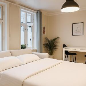 Un dormitorio con una cama blanca y una mesa. en Delightful Bryggen Apartment - Norwegians Minimum Age 25, en Bergen