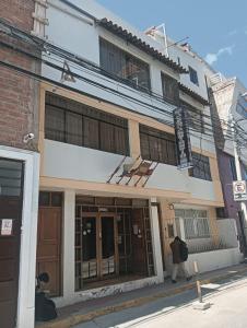 a person walking in front of a building at San Antonio hotel in Puno